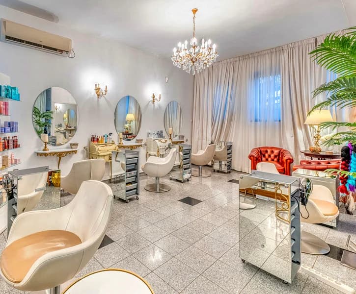 Sala frizerskog salona sa ovalnim ogledalima i lusterom
