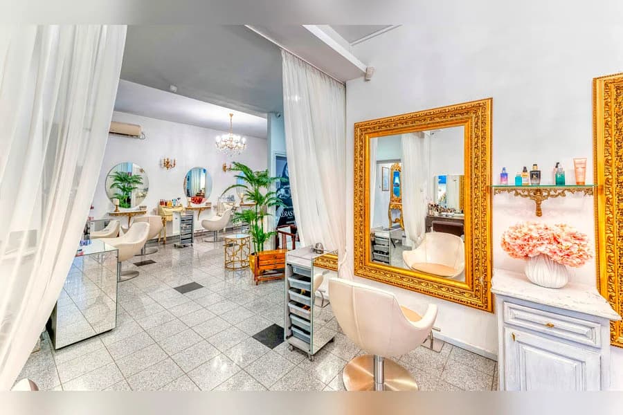 Sala salona sa belim stolicama i zlatnim ogledalom